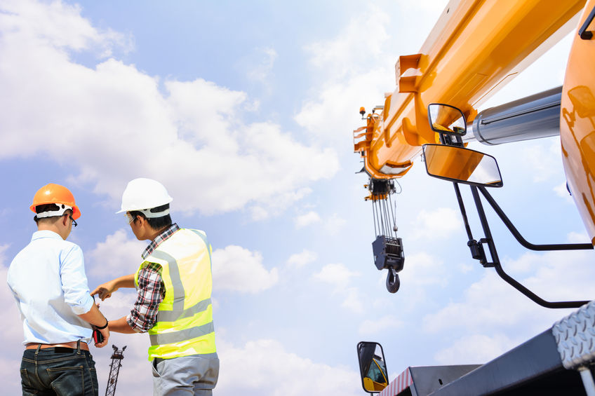 Crane operator talking to construction worker. Crane in background